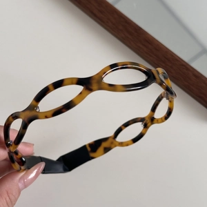 Detailed close-up showing the tortoiseshell pattern and hollow design of the hairband