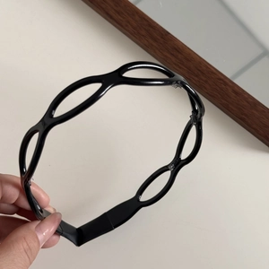 Detail view of the black acetate hollowed-out headband featuring a non-slip toothed design