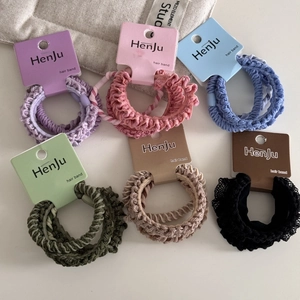 Close-up of 6 colorful elastic hair bands with knit textures on retail card packaging