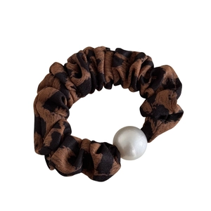 Vintage leopard print scrunchie with large white pearl detail for elegant hairstyles