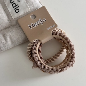 Close-up of woven high-elasticity hair bands in earth tones on display card