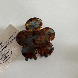 Détail de la pince à cheveux fleur en acétate avec texte France Handmade et écaille