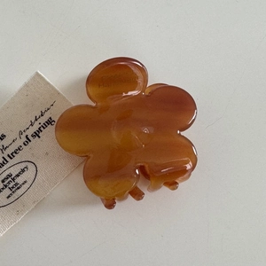 Détail de la pince à cheveux en fleur d'acétate ambré avec une finition brillante