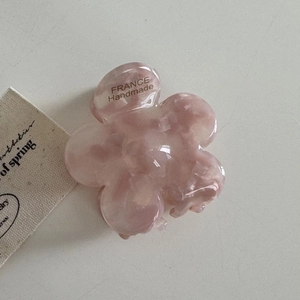 Détail de la pince à cheveux fleur en acétate rose avec marquage France Handmade