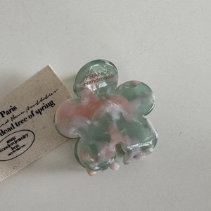 Détail de la pince fleur en acétate avec texture marbrée et marquage France Handmade