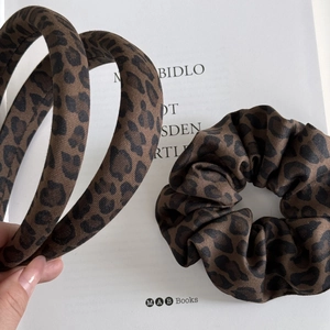 Leopard print headband and scrunchie set made of high-quality twill fabric on book background