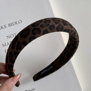 Detail of handmade leopard print headband with thick padded fabric and inner label