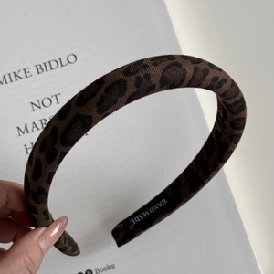 Detailed macro view of leopard print headband with a woven HAND MADE label inside