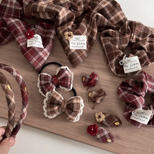 Red plaid hair accessory set featuring bows and handmade flowers on a wooden tray