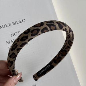 Detail shot of leopard print headband with handmade label and high-crown textured fabric