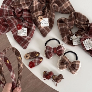 Red plaid hair accessories set with crochet flowers and bows on white background