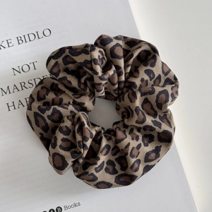 Detail of wide leopard print scrunchie with twill fabric texture on book background