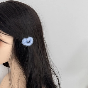 Light blue knitted heart hair clip worn on long black hair for a sweet autumn look