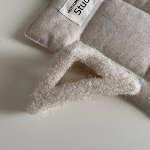Detail der cremefarbenen Plüsch-Haarklammer mit silbernem Glitzerfaden und weichem Fell