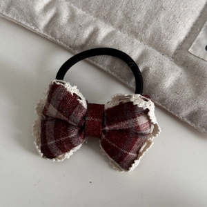 Detail of red plaid bow hair tie with cream lace trim and elastic band for women