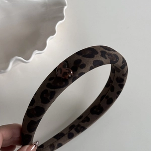 Close-up of leopard print headband with a heart-shaped detail on a white background