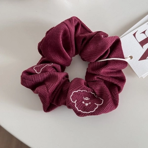 Vue détaillée d'un chouchou en velours côtelé bordeaux avec broderie smiley nuage blanc