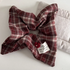 Close-up of red and white checkered hair tie with handmade crochet flower and pearl charm