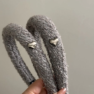 Détail de bandeaux tricotés gris avec paillettes brillantes et détails en forme de cœur argenté