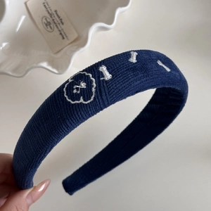Détail du bandeau en tissu bleu marine avec broderie florale blanche et intérieur antidérapant