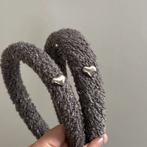 Détail du serre-tête en tricot gris avec cœurs métalliques argentés et texture pailletée