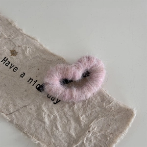Close-up of pink heart-shaped hair clip with soft plush fur texture for girls