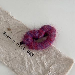 Close-up of fuzzy heart-shaped hair clip with purple and blue mixed yarn texture