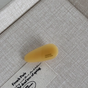 Detailed macro view of handmade amber acetate hair clip with French handmade engraving
