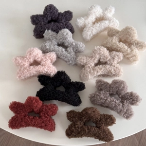 Detailed view of plush star-shaped hair claws in various colors for autumn and winter