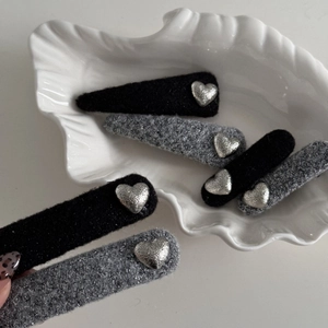 Retro grey and black felt hair clips with textured silver hearts in shell bowl