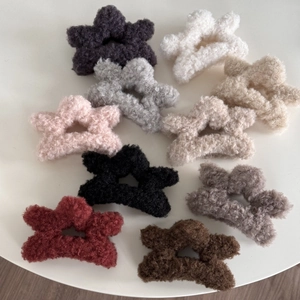 Detail showing plush star hair clips in various colors with soft faux lamb wool texture