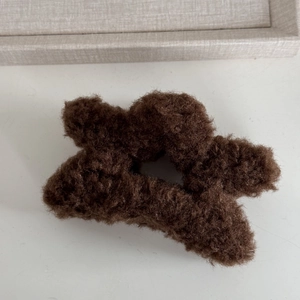 Detail of dark brown plush star hair claw clip with soft faux fur texture close-up