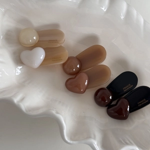 Detail of coffee-toned heart and bead hair clips with gold France Handmade lettering