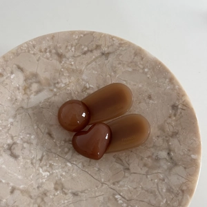 Detail view of amber resin heart and round duckbill hair clips with gold engraving