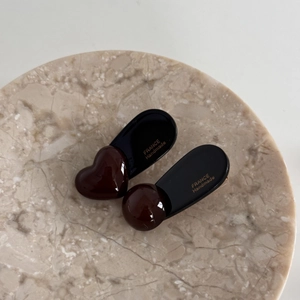 Detail of coffee-toned heart and ball hair clips with France Handmade text on marble