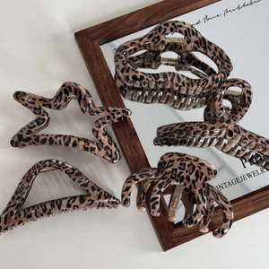Detailed view of leopard print hair claws in vintage resin with durable gold metal springs