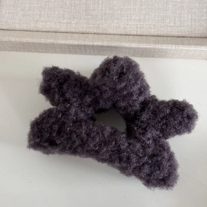 Close-up of a soft grey plush star-shaped hair claw with fuzzy faux shearling texture