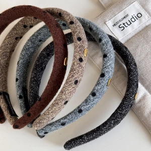 Polka dot wool hairbands with gold metal oval label in warm autumn colors stack