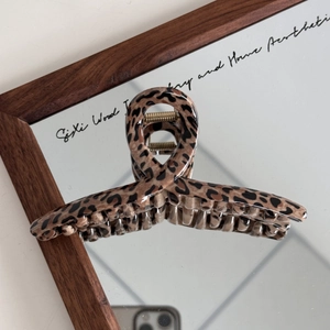 Detailed view of large leopard print hair claw with strong gold metal spring mechanism