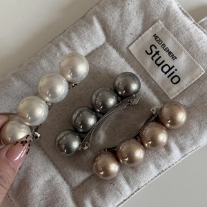 Détail de barrettes à 4 perles en finitions blanc crème, argent et doré champagne
