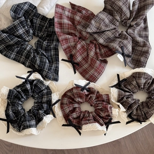 Detailed close-up of checkered scrunchies with white lace edges and small black bows