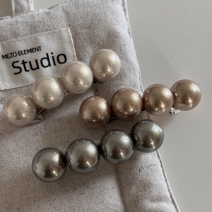 Élégant lot de barrettes à 4 perles en blanc, or et gris sur fond de lin naturel