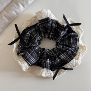 Detail of vintage plaid scrunchie with lace edges and black satin ribbon bows decoration