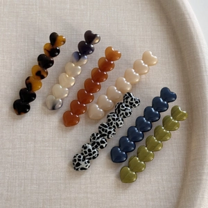 Gros plan de barrettes à cheveux en forme de cœur avec divers motifs colorés