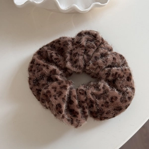 Close-up of soft plush leopard print scrunchie showing detailed brown faux fur texture