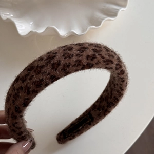Close-up of leopard print plush headband with soft faux fur texture and non-slip lining