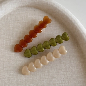 Trois pinces à cheveux en acétate en forme de cœur en ambre, vert olive et crème
