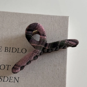 Detail view of pink and dark green checkered fabric hair claw with anti-slip inner teeth
