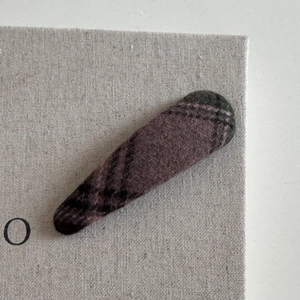 Close-up of classic purple and black checkered plaid fabric texture on a hair clip