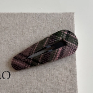 Detail of classic plaid fabric hair clip with pink and dark green checkered pattern